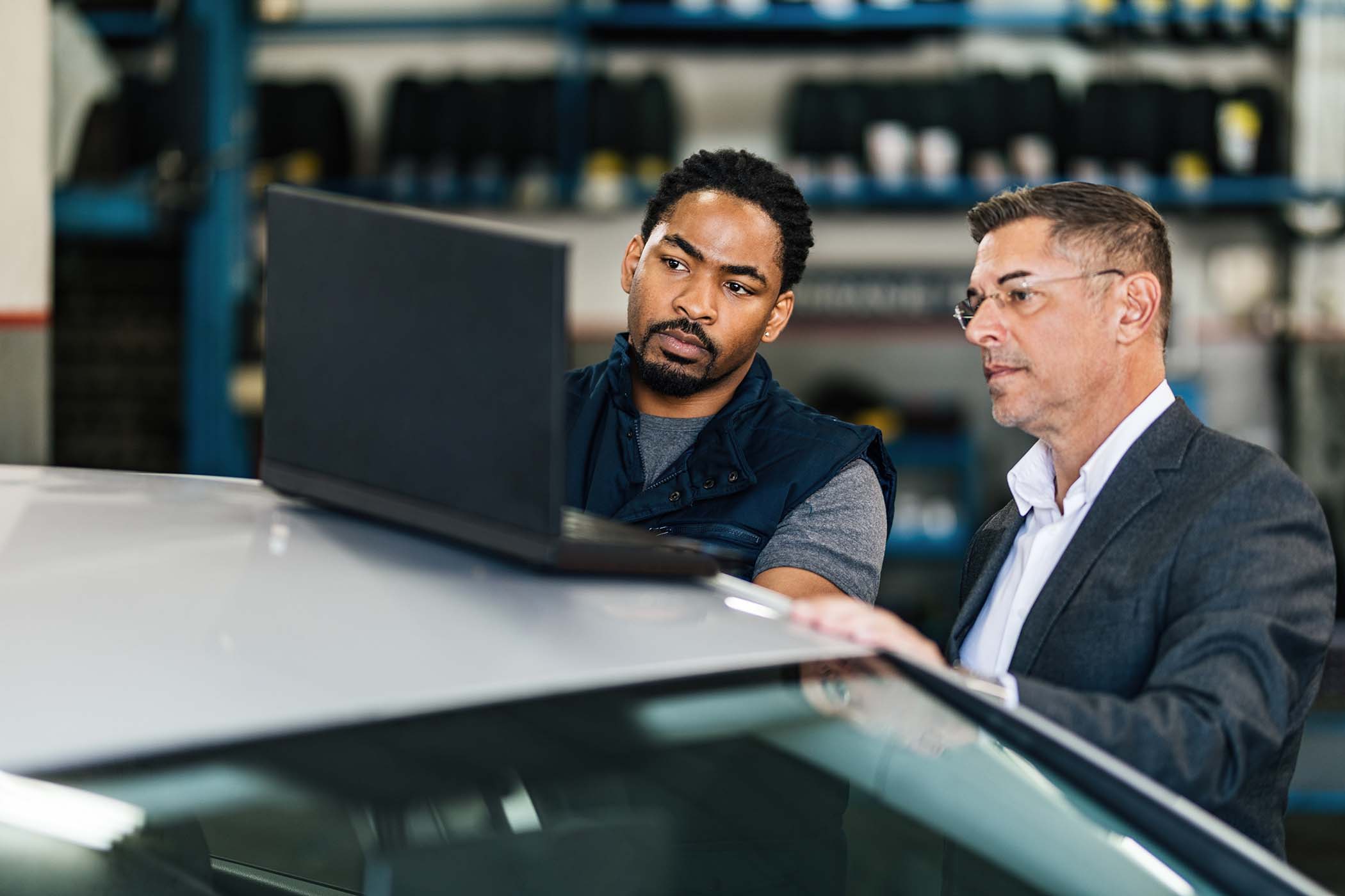 male-customer-and-african-american-car-mechanic-us-9BKUZ7G.jpg